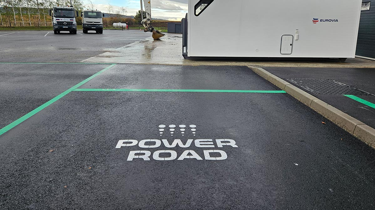 Blick auf eine frisch asphaltierte Straße, auf der mit weißer Farbe "Power Road" geschrieben steht.
