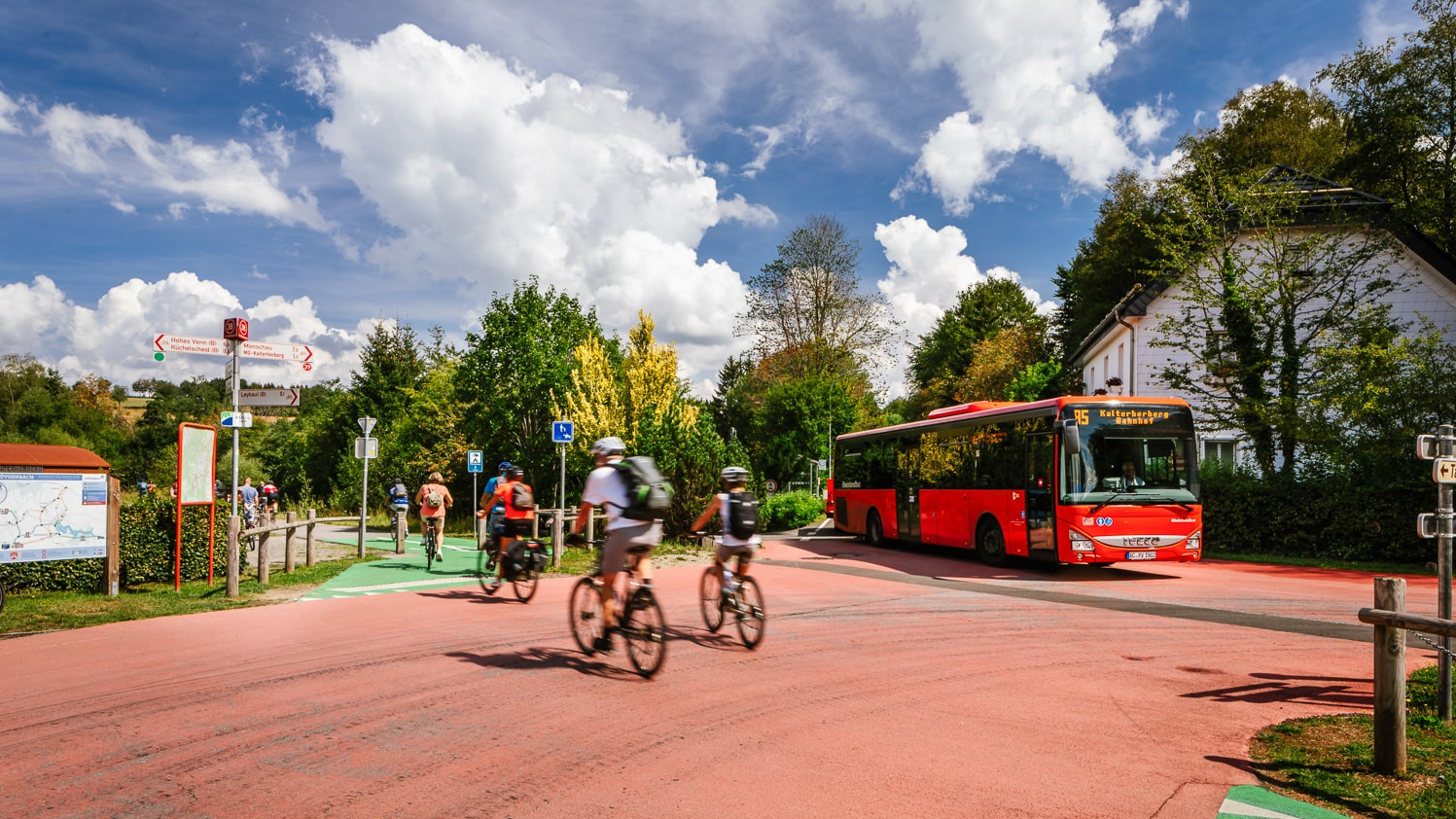 Fahrradfahrende fahren vor einem Bus entlang.