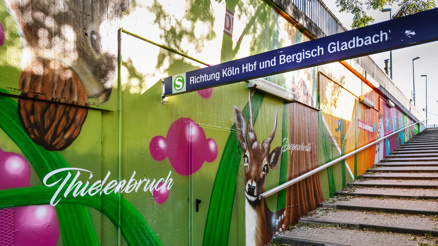 Die Treppe am Ausgang des Bahnhofs Duckterath in Bergisch Gladbach, deren Wände mit einem Kunstwerk mit heimischen Tieren bemalt sind.