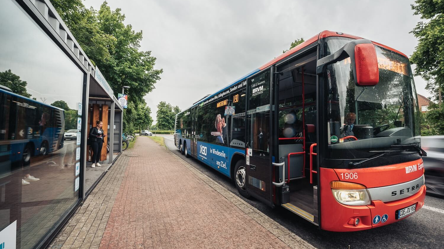 Zwei Busse nebeneinander an einem Bussteig.