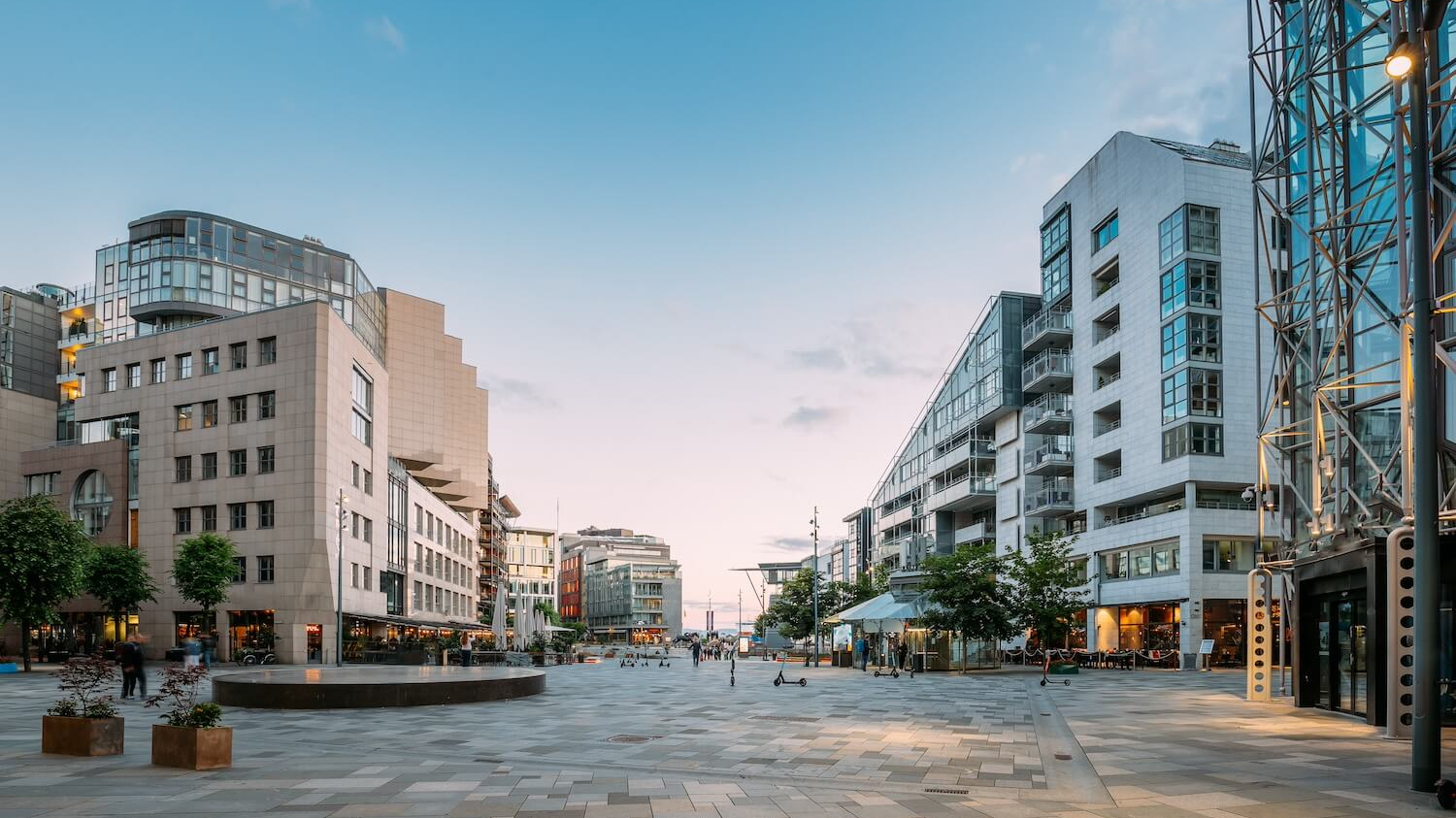 Blick auf einen Platz im Bezirk Aker Brygge in Oslo. Es sind kaum Menschen und keine Fahrzeuge zu sehen.